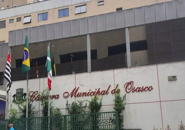 Fachada do prédio da Câmara Municipal de Osasco com bandeiras hasteadas em frente / Concurso Câmara de Osasco