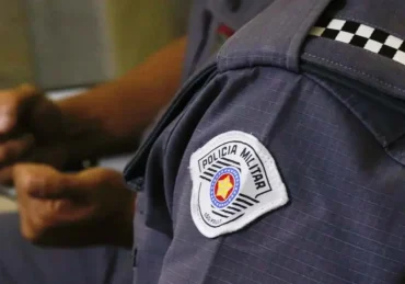 Fotografa de um policial militar, com foco no uniforme e logo da PM SP