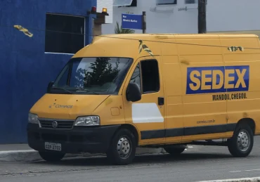 Fotografia de uma van dos Correios (sedex) estacionada na rua