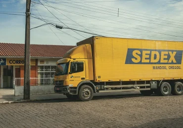 Fotografia de um caminhão dos correios parado na rua